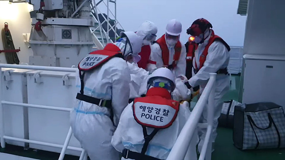동해해양경찰서 대원들이 경비함정을 이용해 호흡곤란 코로나19 응급환자를 긴급 이송하고 있다. (사진 = 동해해경)