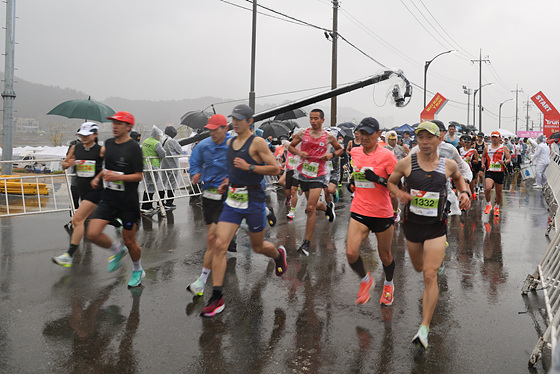 양양 강변 전국 마라톤 대회에 참가한 선수들이 빗속에서 뛰고 있다. (사진 = 양양군)