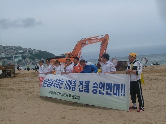 NSP통신-해운대를 죽이는 108층 건물승인 반대 퍼포먼스를 벌이고 있다. <사진제공=부산참여연대>