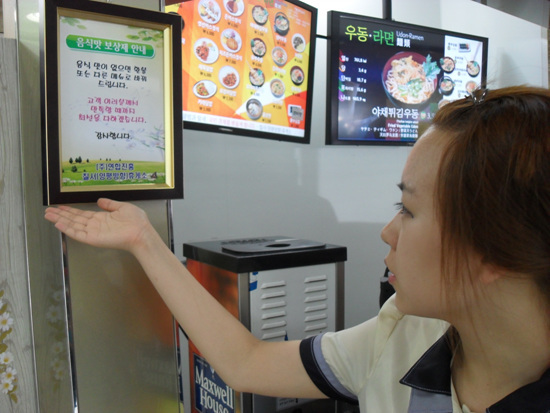 NSP통신-한국도로공사 구마고속국도 칠서휴게소 직원이 음식맛 보상제 안내문을 가리키고 있다.<사진제공=칠서고속도로휴게소>