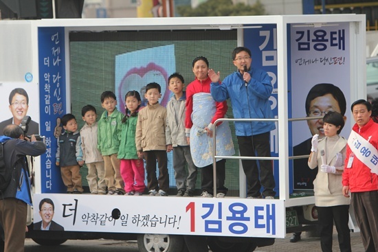 NSP통신-김용태 의원이 유세차에 올라온 7자녀 다둥이가족 정애숙씨 가족을 소개하고 있다.