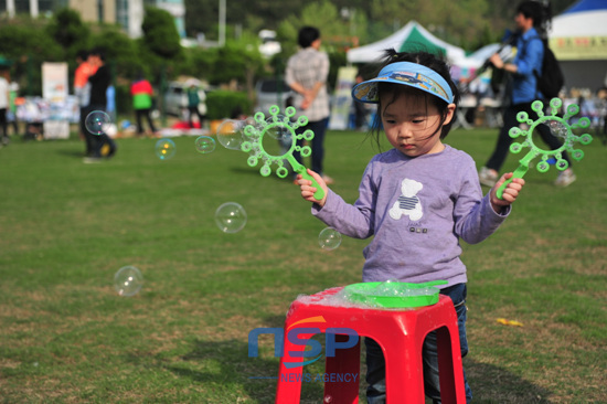 NSP통신-오륙도 축제에 참가한 한 어린이가 잔디밭에서 비누방울을 만들며 즐거워 하고 있다.