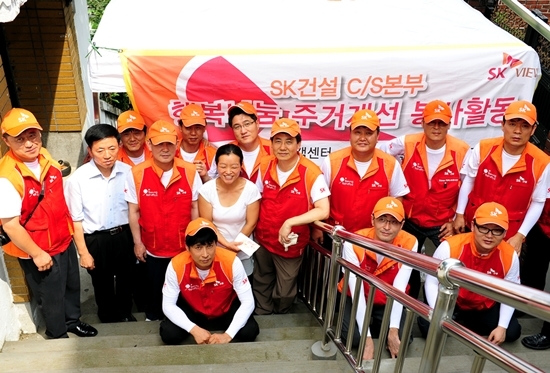 NSP통신-최광철 사장(오른쪽 여섯 번째)을 비롯한 SK건설 임직원들이 희망메이커 행복마을 가꾸기 대상 가족과 함께 기념사진을 찍고 있다.