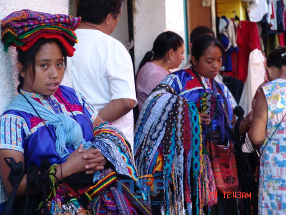NSP통신-원주민 소녀들이 수공예품 직물들을 한아름 안고 팔고 있다.