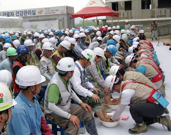 NSP통신-경기 고양시 도내동의 아파트 공사 현장에서 안전을 관리·감독하는 SK건설 직원들이 현장 근로자들의 발을 씻겨주는 세족식을 진행하고 있다.