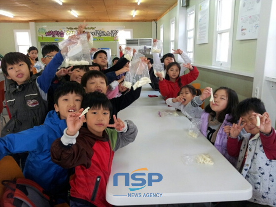 NSP통신-서생초등학교가 무상지원하는 체험학습 밀크스쿨에 참여한 학생들이 저마다 본인이 만든 치즈를 자랑하며 사진을 찍고 있다. (서생초등학교 제공)
