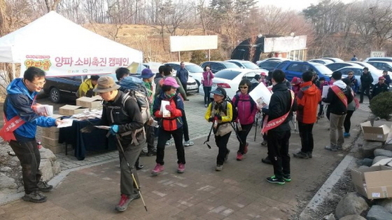 NSP통신-농협중앙회 임직원들이 청계산 등반객에게 소비촉진 홍보용 양파세트를 나눠주고 있다. (농협중앙회 제공)