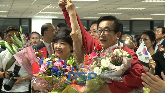 NSP통신-4일 오후 11시 부산 사하구 하단동의 서병수 부산시장 후보 캠프에서 서 후보가 부인과 함께 꽃다발을 받아들고 지지자들의 환호에 화답하고 있다.