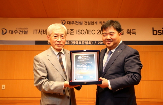 NSP통신-대우건설 이훈복 경영지원실장(오른쪽)과 BSI Korea 천정기 회장(왼쪽)이 ISO/IEC 20000 인증패를 들고 기념촬영을 하고 있다.