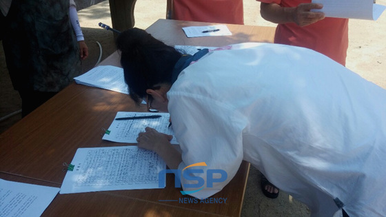 NSP통신-27일 성주사 경내에서 펼쳐진 서명운동에 한 불자가 서명을 하고 있다. 이날 서명운동에는 평소보다 2배이상 몰려든 불자들이 모두 서명했다. (김경옥 기자)