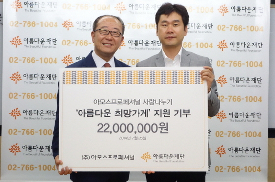 NSP통신-박준서 아름다운재단 사무총장(왼쪽)과 황동희 아모스프로페셔널 대표이사가 협약식을 마치고 기념 사진을 촬영하고 있다 (아모스프로페셔널 제공)