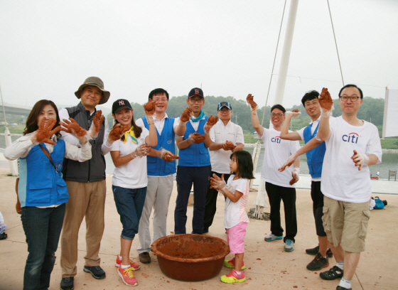 NSP통신-지난 8월 23일 한국씨티은행, 한국수자원공사, 인천YWCA 임직원들이 인천광역시 검안동을 지나는 경인 아라뱃길 인근에서 수질정화 활동에 사용할 EM 흙공을 제작하고 있다.