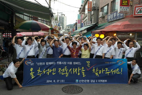 NSP통신-김영표 신한은행 부행장(앞줄 왼쪽에서 다섯 번째)를 비롯한 신한은행 임직원들이 서울 동작구 사당동의 남성시장에서 전통시장이용캠페인을 진행하고 시장상인들과 함께 기념촬영을 하고 있다.