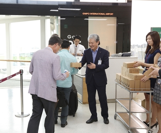 NSP통신-한국공항공사 관계자가 아시아나항공, OZ3615호 탑승객 전원에게 한국공항공사 마스코트인 포티를 모티브로 제작된 에코 텀블러가 기념품을 제공하고 있다.