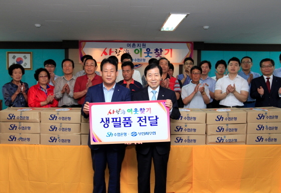 NSP통신-이원태 수협은행장(앞줄 오른쪽)이 3일 부산시수협(조합장 양정명, 앞줄 왼쪽)을 방문해 어민 지원을 위한 생필품을 전달하고 기념촬영을 하고 있다.