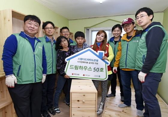 NSP통신-서울 종로구에서 최근 진행된 시각장애아동 공부방 개선사업인 드림하우스 봉사활동에 참여한 스탠다드차타드은행 임직원 자원봉사자와 수혜자가 드림하우스 50호점을 완성했다.