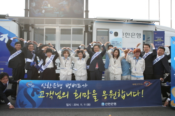 NSP통신-김영표 신한은행 부행장(왼쪽에서 여섯번째)과 직원들이 이동점포 행사 후 고객들과 함께 기념촬영을 하고 있다.