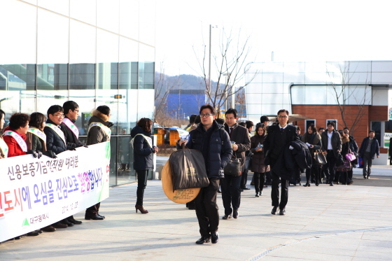 NSP통신-22일 오전 대구혁신도시 신보 신사옥에서 대구시 관계자 및 대구은행 직원이 출근하는 신보직원을 환영하고 있다.