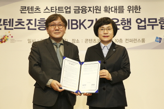 NSP통신-권선주 기업은행장(오른쪽)과 송성각 한국콘텐츠진흥원장(왼쪽)이 12일 서울 종로구 대학로 콘텐츠코리아랩에서 협약식을 마치고 기념촬영을 하고 있다.