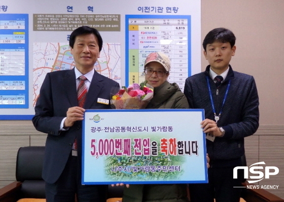 NSP통신-빛가람동 주민센터 김원채동장(사진 왼쪽)이 지난 25일 5000번 째 전입주민 김영희(사진 가운데)씨에게 꽃다발을 전달하고 있다. (나주시)