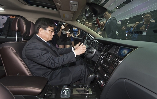 NSP통신-2015 서울모터쇼의 르노삼성자동차관을 방문한 산업통상자원부 윤상직 장관이 세계 최초로 마그네슘 판재가 적용된 르노삼성자동차 SM7 Nova에 올라 설명을 듣고 있다.