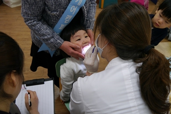 NSP통신-유디치과 의료진으로부터 구강검진을 받고 있는 어린이