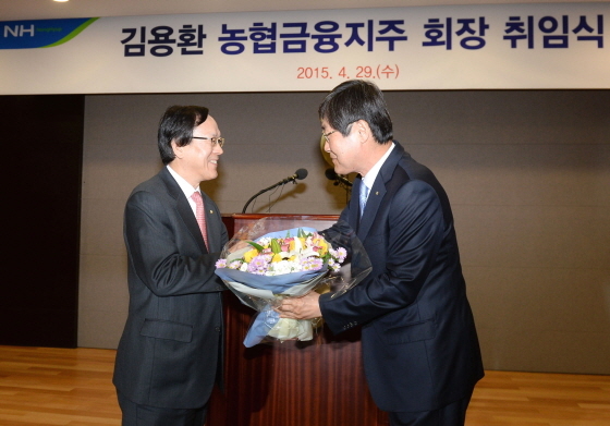 NSP통신-김용환 NH농협금융지주 신임 회장(좌측)이 김정식 농협중앙회 부회장(우측)으로부터 꽃다발을 받고 있다.