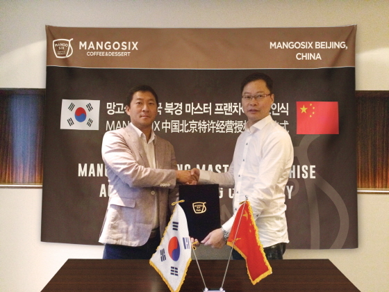 NSP통신-강훈 망고식스 대표(왼쪽)가 지난 8일 상해에서 마초걸 북경망과희사찬음관리유한공사 대표(오른쪽)와 망고식스의 북경, 천진, 하북성 사업에 대한 마스터 프랜차이즈 계약을 체결한 후 기념촬영을 하고 있다. (망고식스 제공)