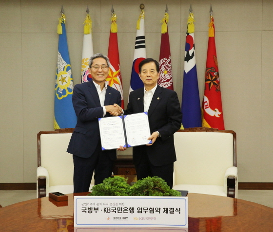 NSP통신-21일 오후 국방부 장관 접견실에서 군인가족과 함께하는 작은도서관 설치·운영을 위한 업무협약을 체결하고 윤종규 KB국민은행 은행장(왼쪽)과 한민구 국방부 장관(오른쪽)이 기념촬영을 하고 있다.