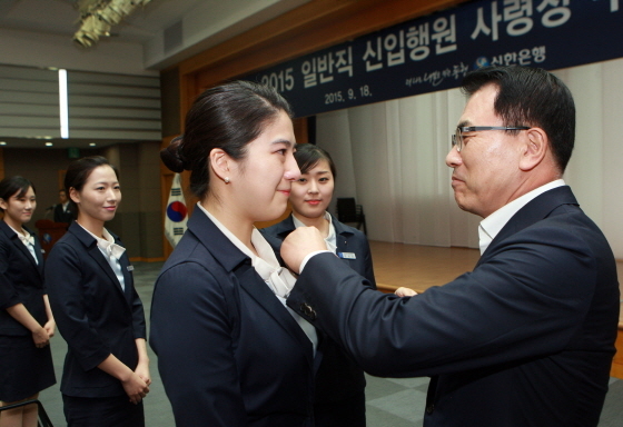 NSP통신-신한은행 본점에서 열린 신입직원 사령장 수여식에서 조용병 신한은행장이 신입직원에게 행표를 직접 달아주고 있는 모습(사진제공=신한은행)