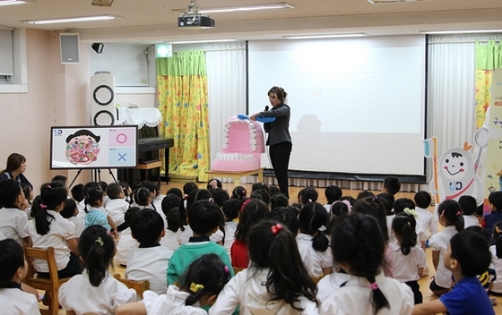 NSP통신-유디치과(고덕점) 치위생사가 구강모형을 이용하여 올바른 칫솔질 교육을 하고 있다