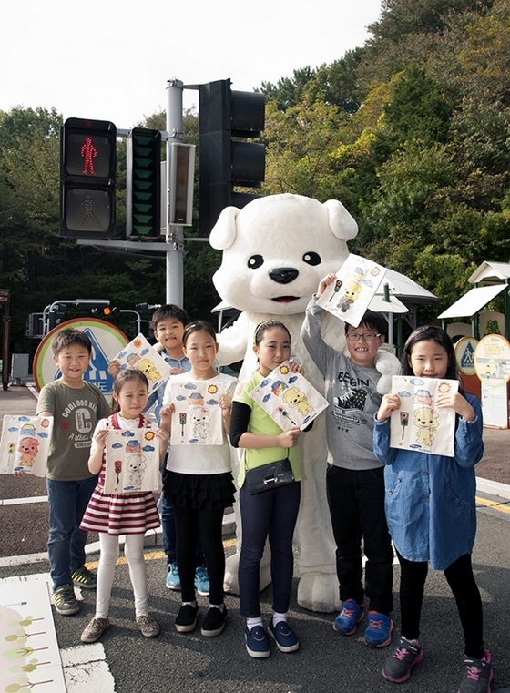 NSP통신-르노삼성차 어린이교통안전 캠페인에 참여한 어린이가 안전벨트 커버를 만들고 기념촬영을 하고 있다.