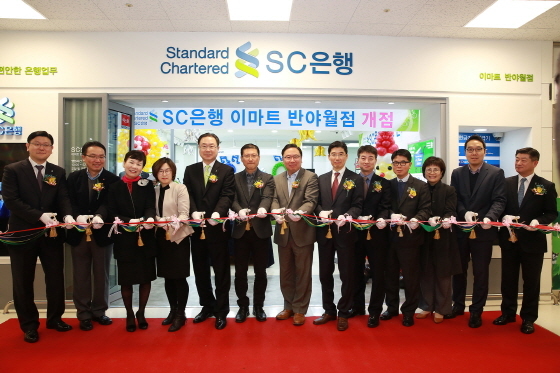 NSP통신-지난 14일 대구 이마트 반야월점에 오픈한 한국SC은행 뱅크샵 개점식에서 한국SC은행 리테일금융총괄본부장 윤패트릭 전무(왼쪽 일곱 번 째)가 임직원들과 함께 개점식을 진행하고 있다.(사진제공=SC은행)