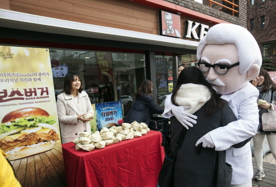 NSP통신-지난 30일 KFC 대학로점 앞에서 신메뉴 보스버거 출시를 기념하는 허그 이벤트를 진행하고 있다. (KFC 제공)
