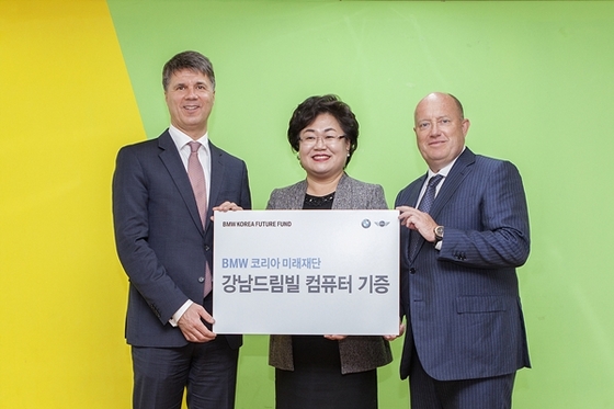 NSP통신-하랄드 크루거 BMW 그룹 회장(좌측)과 헨드릭 본 퀸하임 BMW 그룹 아시아 태평양 남아프리카 총괄 사장(우측)이 이은영 강남드림빌 원장(가운데)과 컴퓨터 기증식 기념 촬영을 하고 있다