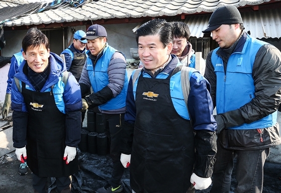 NSP통신-한국지엠 제임스 김 사장(오른쪽)과 전국금속노동조합 한국지엠지부 고남권 지부장(왼쪽)이 연탄을 나르고 있는 모습.