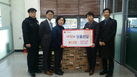 NSP통신-오희영 포항 예스치과 대표원장(왼쪽 세번째)이 죽도동 주민센터를 방문해 쌀과 라면을 전달하고 있다 (포항 예스치과)