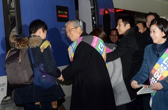 NSP통신-김종인 비대위원장이 용산역에서 설 연휴를 맞아 고향에 내려가는 한 귀성객에게 팜플렛을 나눠주고 있다.