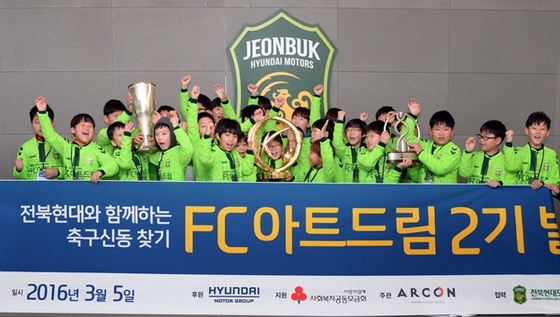 NSP통신-FC아트드림 2기 참여 아동들이 전북현대모터스FC의 과거 우승컵을 들고 기념 촬영하는 모습