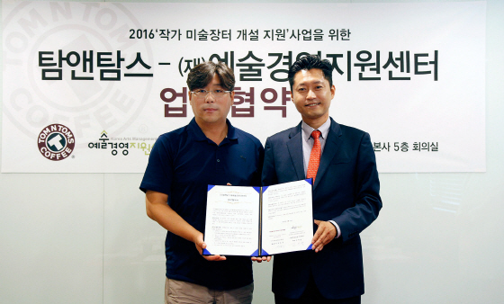 NSP통신-김도균 탐앤탐스 대표(오른쪽)와 예술경영지원센터 김선영 대표가 업무협약을 체결 후 기념촬영을 하고 있다. (탐앤탐스 제공)