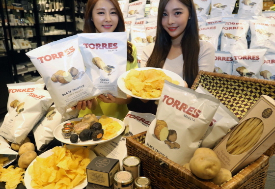 NSP통신-23일 서울시 중구 신세계백화점 본점 식품관에서 모델들이 캐비어(철갑상어)와 트러플(송로버섯)이 들어간 감자칩을 선보이고 있다. (신세계 제공)