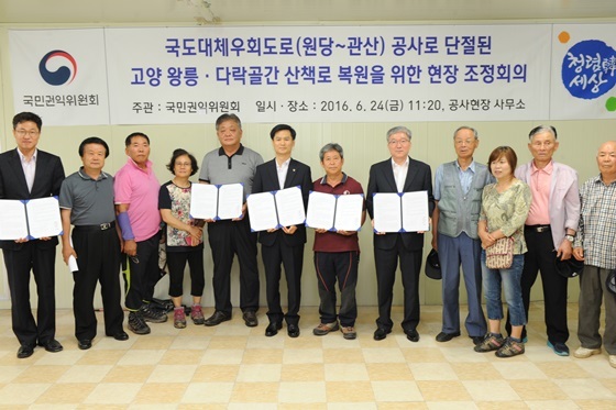 NSP통신-국민권익위 김인수 부위원장이 경기도 고양시 민원 현장에서 도로공사로 단절된 산책로 복원 요구 집단민원에 대해 현장조정회의를 개최하고참석자와 기념촬영을 하고 있다. (국민권익위원회)