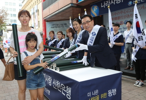 NSP통신-조용병 신한은행장이 광복 71주년을 기념해 명동에 방문한 시민들에게 태극기를 나눠주고 있다.