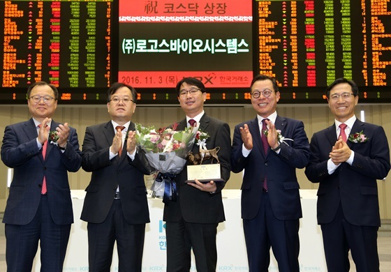 NSP통신-상장기념패 전달 후 기념촬영 왼쪽부터 임승원 한국IR협의회 부회장, 김재준 한국거래소 코스닥시장위원회 위원장, 정연철 (주)로고스바이오시스템스 대표, 김종옥 신한금융투자 IB본부장,김원식 코스닥협회 부회장 (한국거래소)