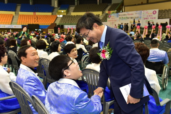 NSP통신-지난 4월 열린 제36회 장애인의 날 행사에서 염태영 수원시장(우)이 참석자와 인사를 나누는 모습. (수원시청 제공)
