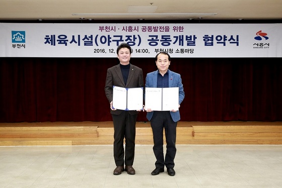 NSP통신-▲김만수 부천시장(왼쪽)과 김윤식 시흥시장(오른쪽)이 협약서를 보이고있다 (부천시청 제공)