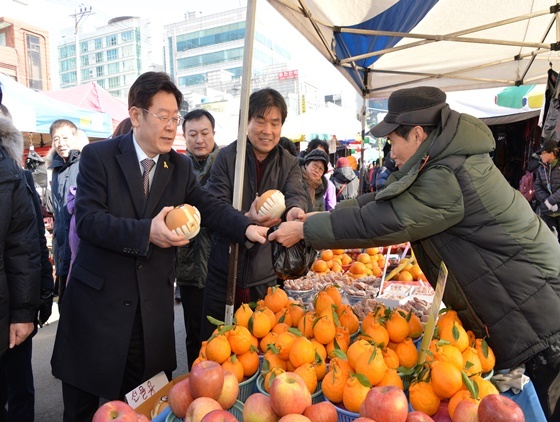 NSP통신-시장 상인들로 부터 과일을 직접 구입하는 이재명 성남시장. (성남시 제공)