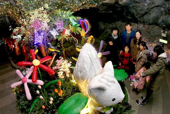 NSP통신-18일 광명동굴 봄, 빛으로 깨우다 축제에 참석한 관광객들이 웜홀광장에 조성된 토피어리를 관람하고 있다. (광명시)