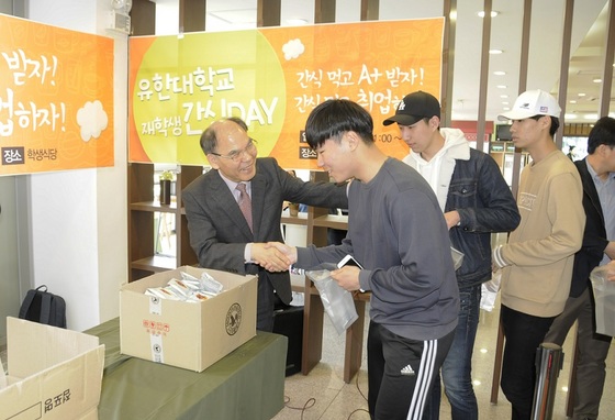 NSP통신-이권현 유한대학교 총장(왼쪽)이 직접 간식을 재학생들에게 나눠주고 있다. (유한대학교)