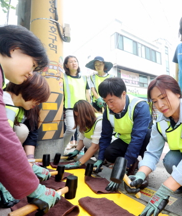 NSP통신-9일 경기 용인초등학교에서 옐로카펫 설치를 돕고 있는 정찬민 용인시장. (용인시)